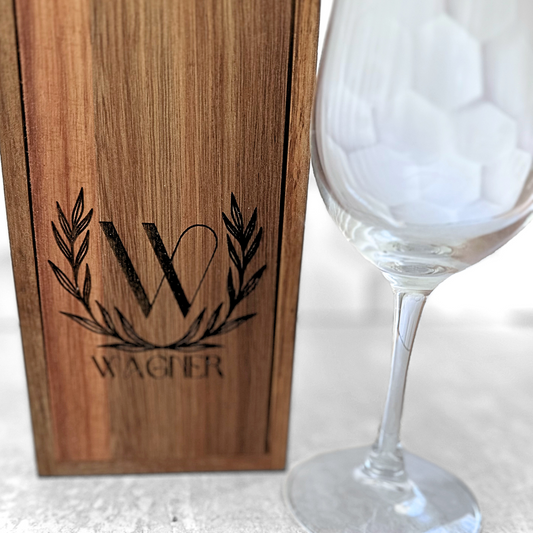 a wine glass sitting next to a wooden box